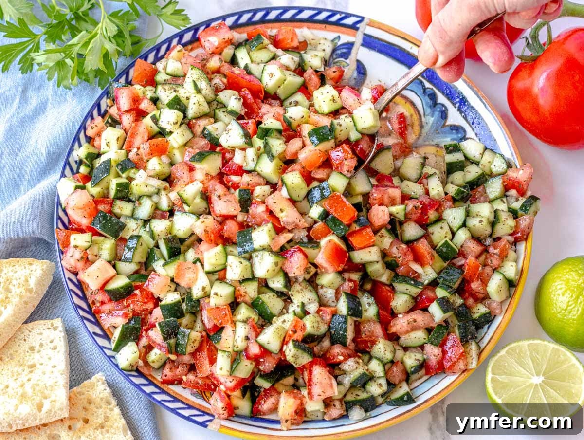 Vibrant Shirazi Chopped Salad 7 Shirazi salad after mixing on a plate with fresh lime and tomatoes on the side