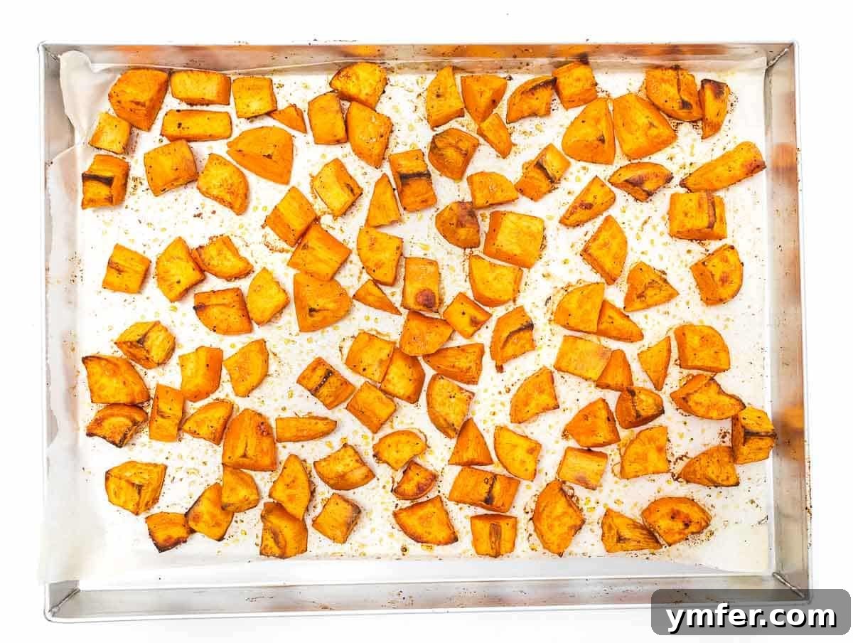 Golden Roasted Sweet Potatoes 8 roasted sweet potato cubes on a baking sheet