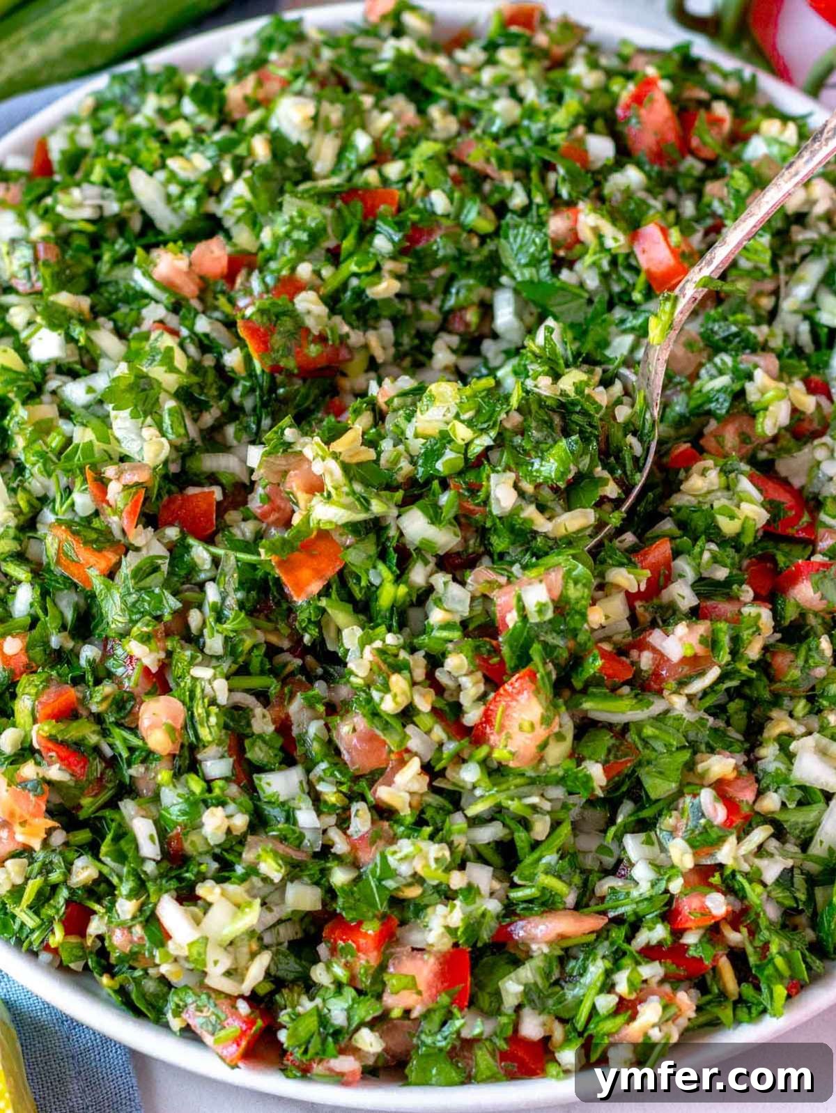 Fresh and Zesty Tabbouleh Salad 3 Close-up of a fresh tabouli (tabbouleh) recipe showing finely chopped parsley, bulgur, tomatoes, and mint in vibrant detail, highlighting the fresh ingredients.