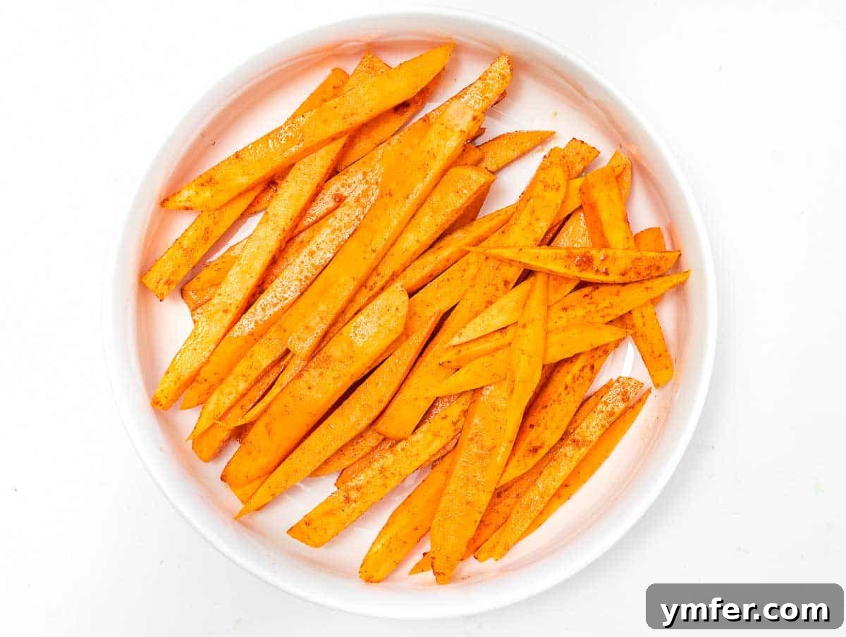 Golden & Crispy Air Fryer Sweet Potatoes 18 Sweet potato fries tossed in olive oil and seasoning, ready for the air fryer.