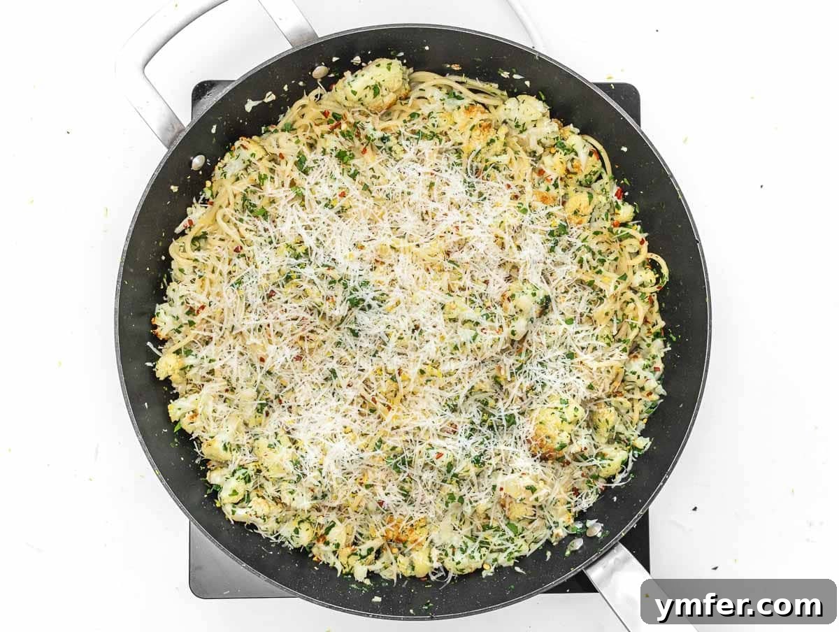 Velvety Cauliflower Pasta 11 Pasta with roasted cauliflower and melted cheese in a pan, tossed together.