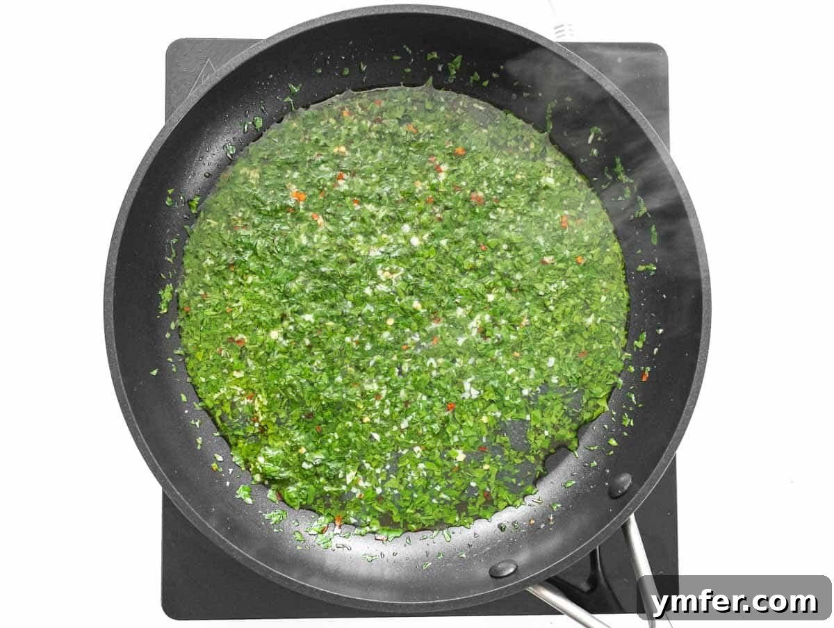 Velvety Cauliflower Pasta 8 Finely chopped parsley being fried with garlic and olive oil in a pan.