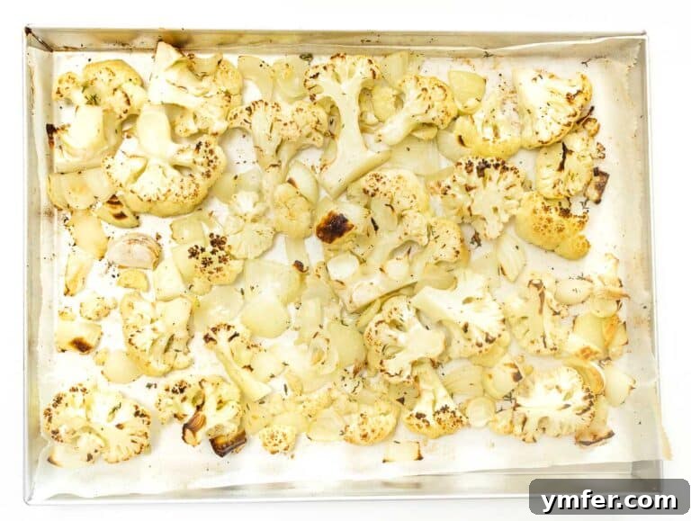 Roasted cauliflower florets beautifully arranged on a baking tray
