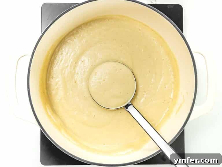 Warming up the cauliflower soup in a Dutch oven on the stovetop