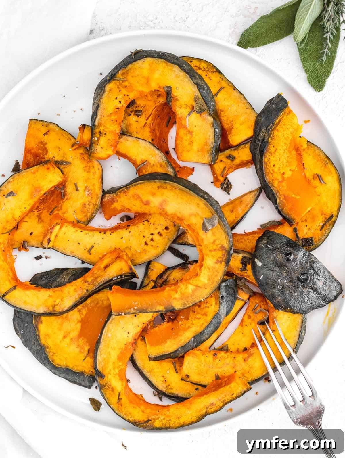 Golden Roasted Kabocha 2 Beautifully roasted kabocha squash wedges presented on a white plate, highlighting their vibrant orange flesh and tender texture, garnished with fresh herbs.