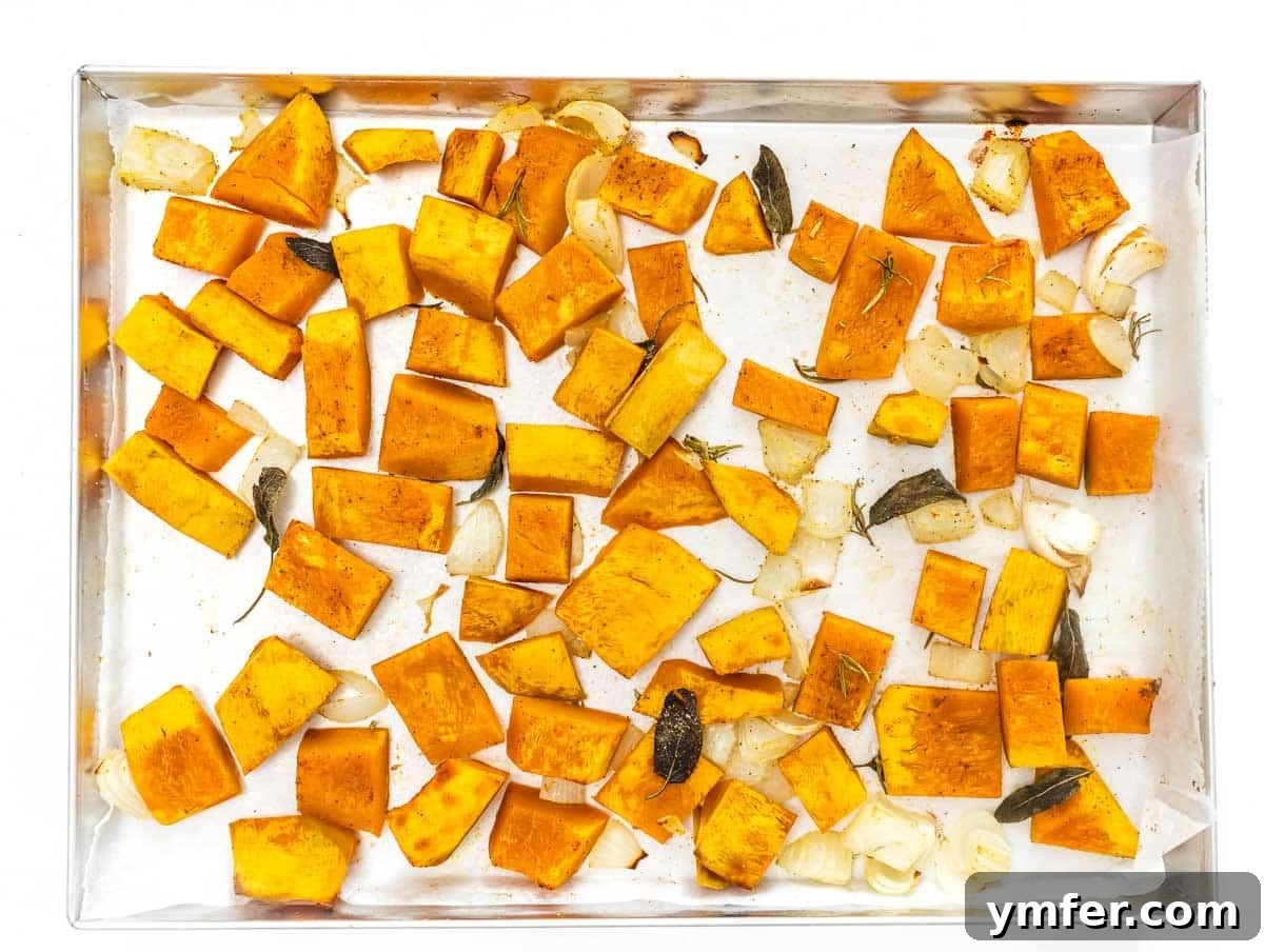 Golden Roasted Kabocha 12 Perfectly diced and roasted kabocha squash cubes on a baking tray, garnished with fresh herbs.