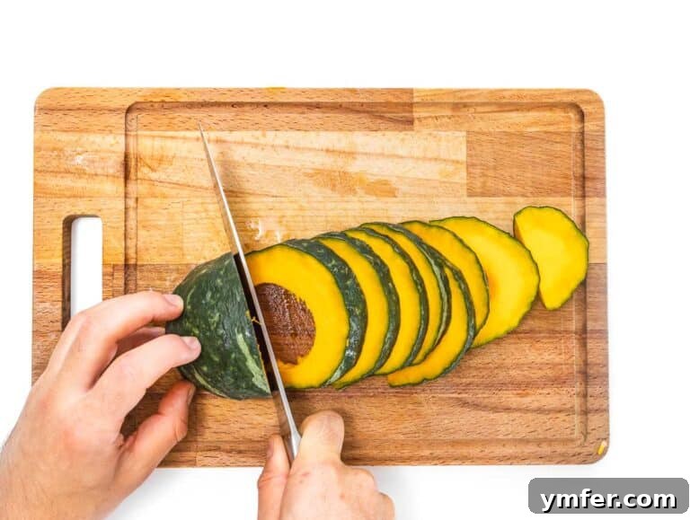 Golden Roasted Kabocha 6 A clean acorn squash perfectly halved and seeded, with one half placed cut-side down on a cutting board, ready for slicing.