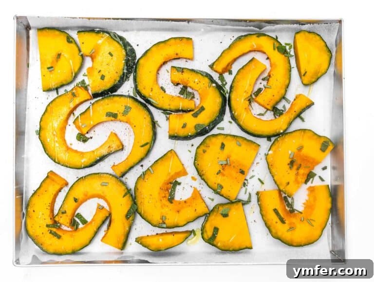 Golden Roasted Kabocha 8 Kabocha squash wedges on a baking tray, generously seasoned with olive oil, herbs, salt, and pepper, before roasting.