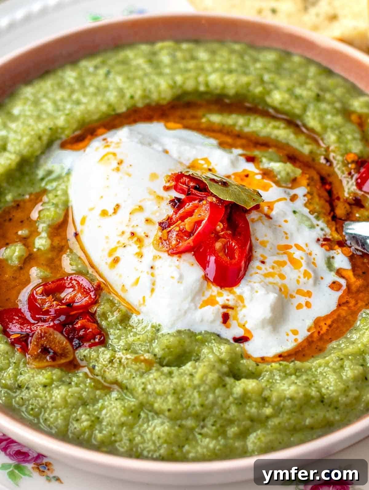 Vibrant Broccoli Cream 2 Creamy broccoli soup served with burrata cheese and a vibrant drizzle of chili oil, inviting presentation.