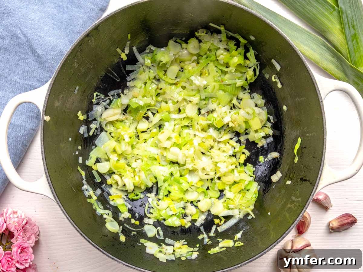 Vibrant Broccoli Cream 7 Leek and garlic sautéing in olive oil in a Dutch oven, forming the aromatic flavor base for the broccoli soup.