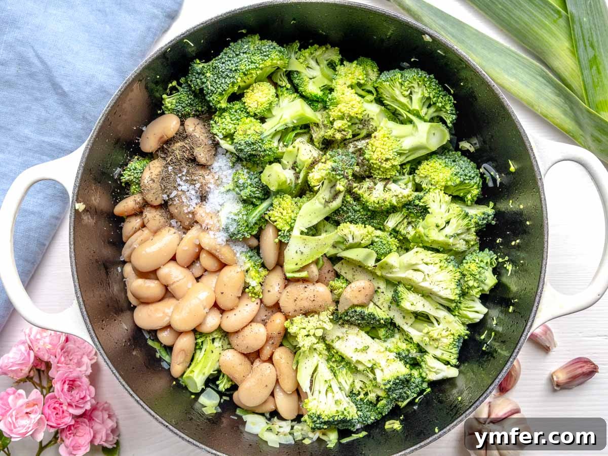 Vibrant Broccoli Cream 8 Chopped broccoli, white beans, salt, and pepper added to the Dutch oven with the sautéed leek and garlic, ready for simmering.
