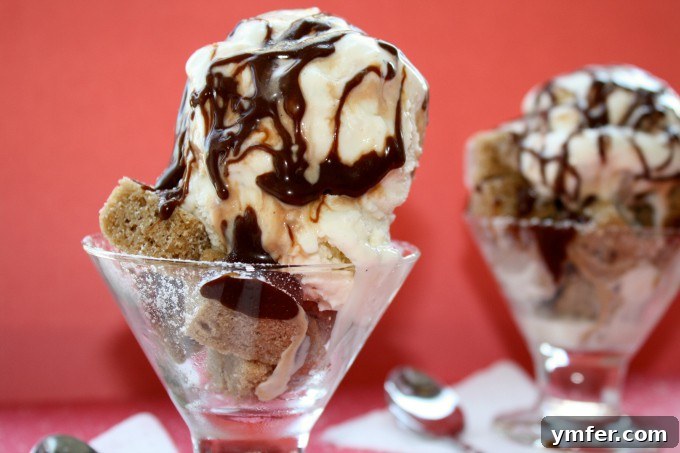 Pound Cake Parfait Sundae via Nutmeg Nanny Delicious pound cake parfait sundae with a spoon, highlighting the layers of cake, ice cream, and fudge.