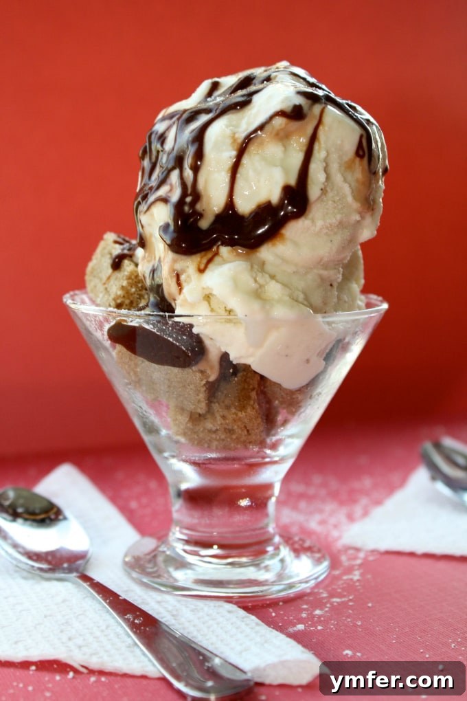 Pound Cake Parfait Sundae via Nutmeg Nanny Close-up of a pound cake parfait sundae, showcasing the golden cake, white ice cream, and dark fudge.
