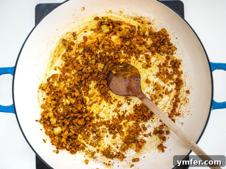 Assorted spices being toasted in a blue skillet.