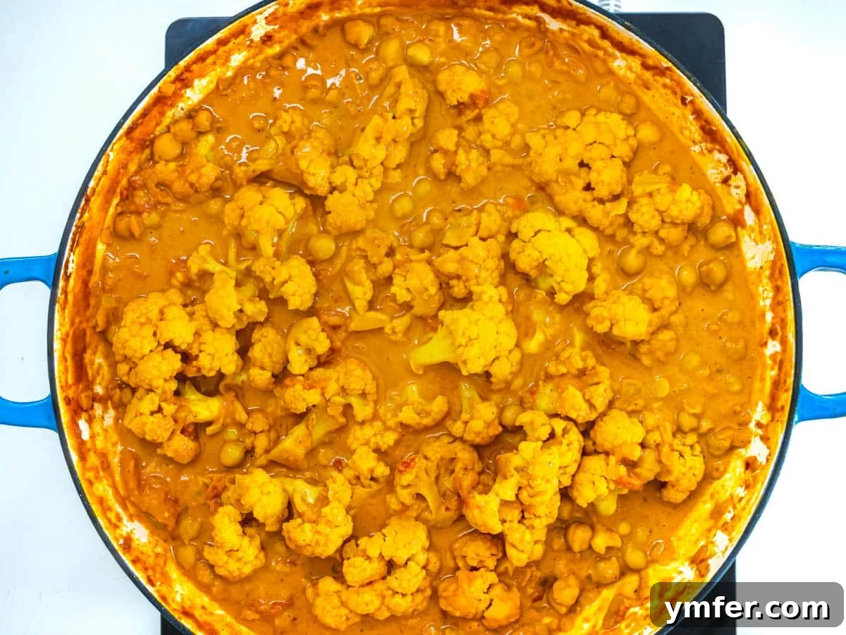 Golden Cauliflower Curry 6 A finished cauliflower curry served in a blue skillet, garnished and ready.