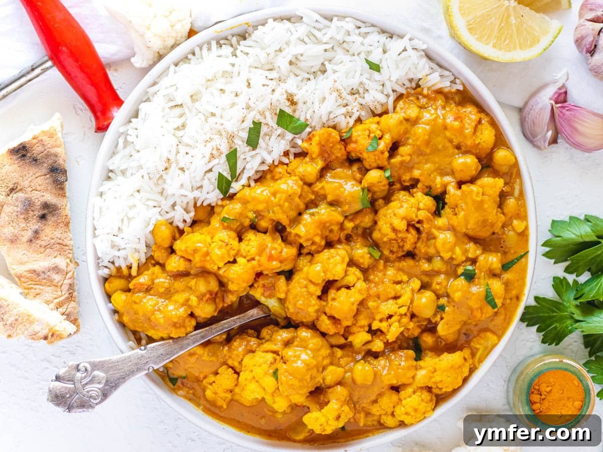 Golden Cauliflower Curry 7 Cauliflower Curry served with a spoon and fresh garnish.