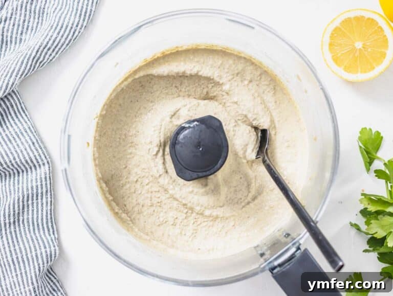 Lentil hummus after blending with a black spoon
