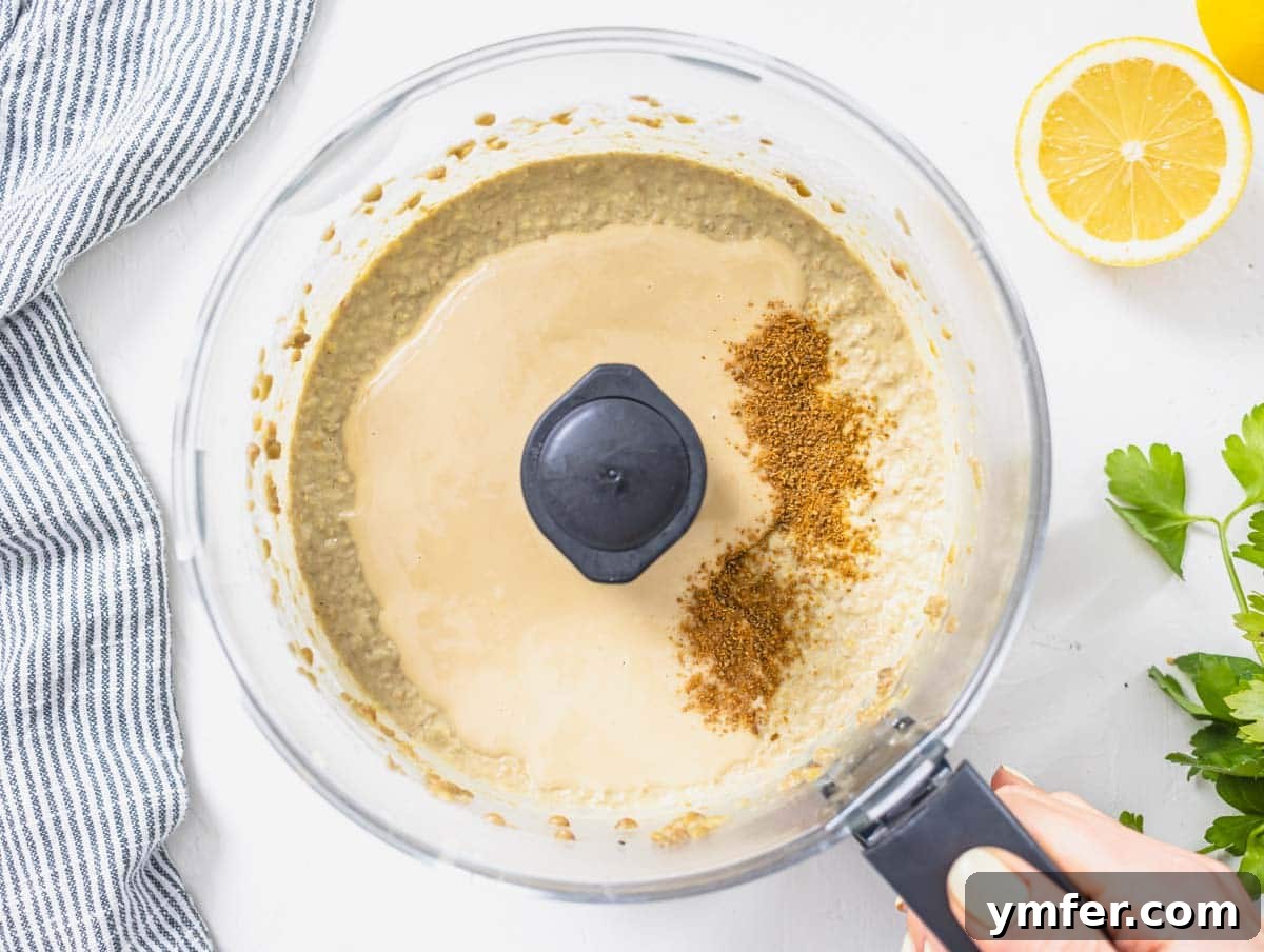tahini and cumin added to lentil blend in a food processor