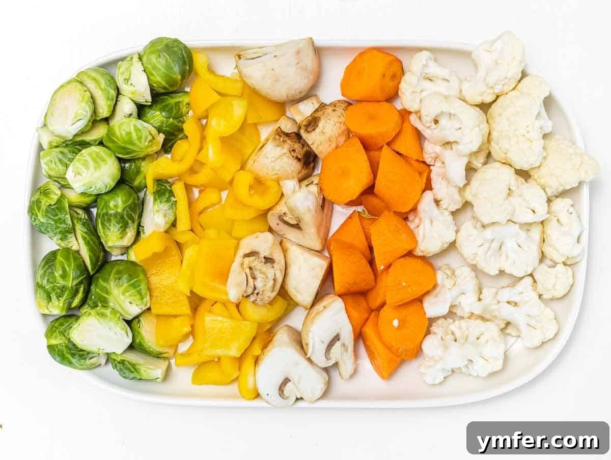 Sheet Pan Roasted Delights 5 Various chopped vegetables, including Brussels sprouts, cauliflower, and carrots, ready for seasoning before baking