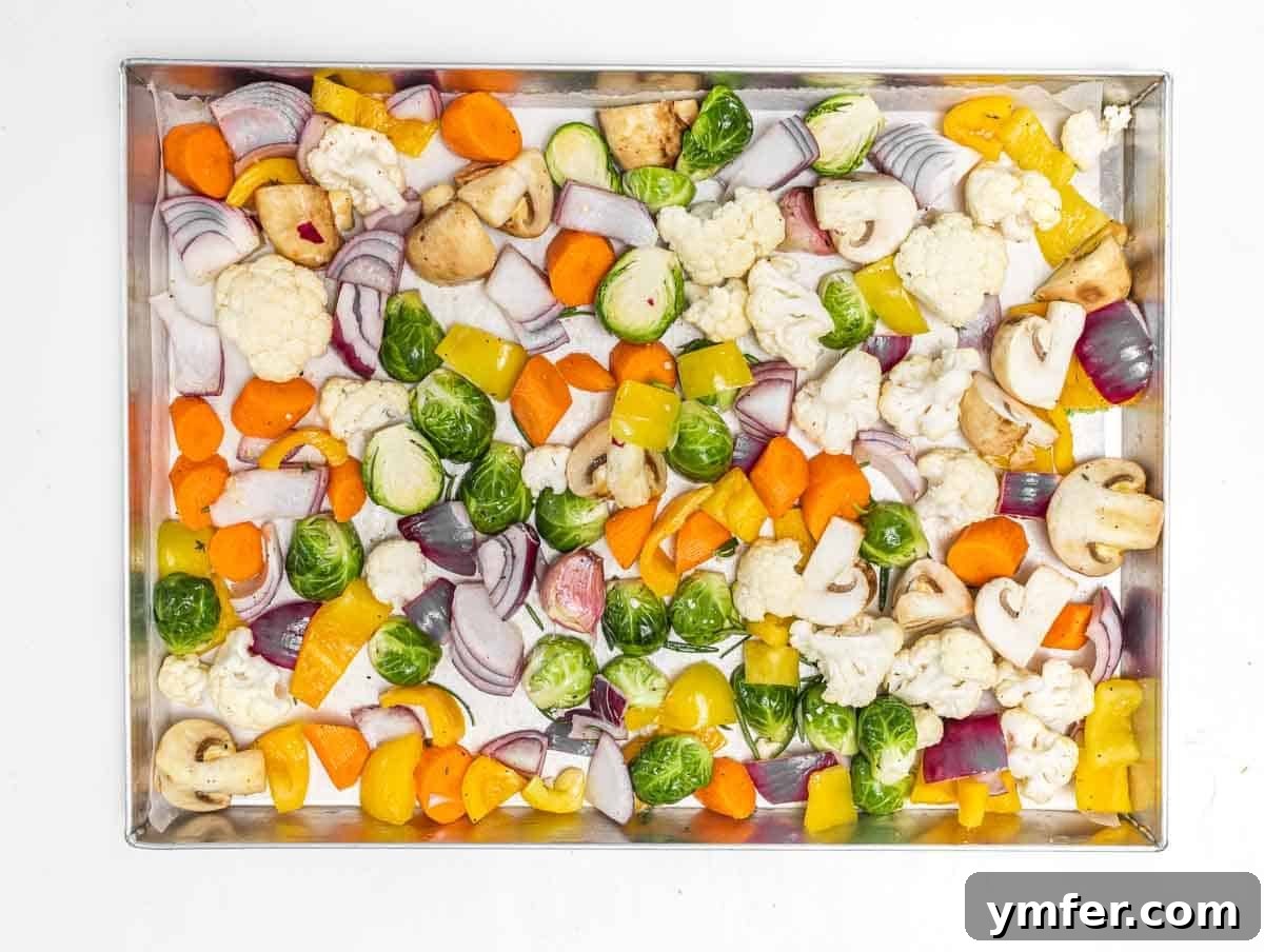Sheet Pan Roasted Delights 7 Seasoned vegetables spread evenly in a single layer on a baking tray, ready for the oven