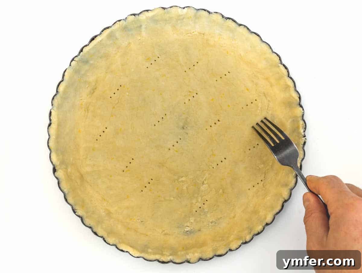 pie crust in a tart pan, pricked with a fork