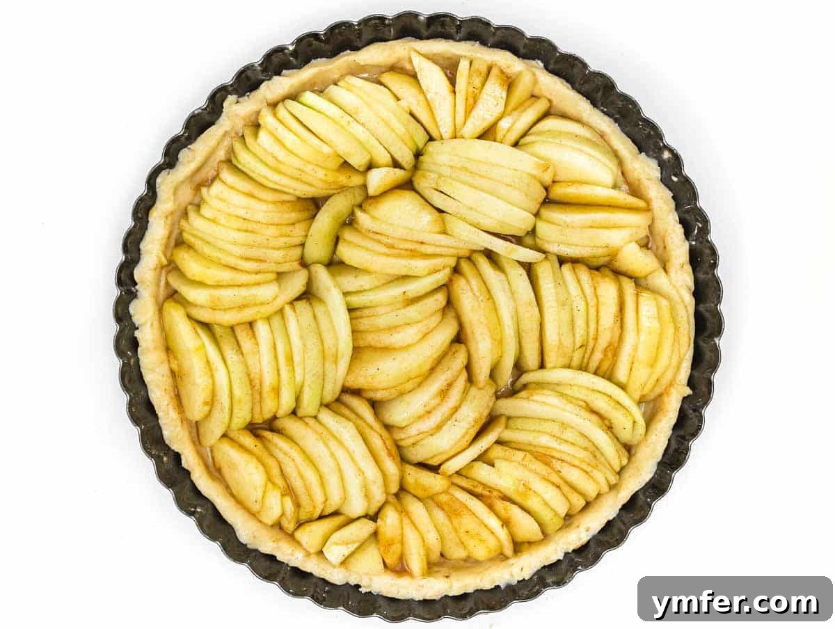 apple slices on top of pie crust, artfully arranged