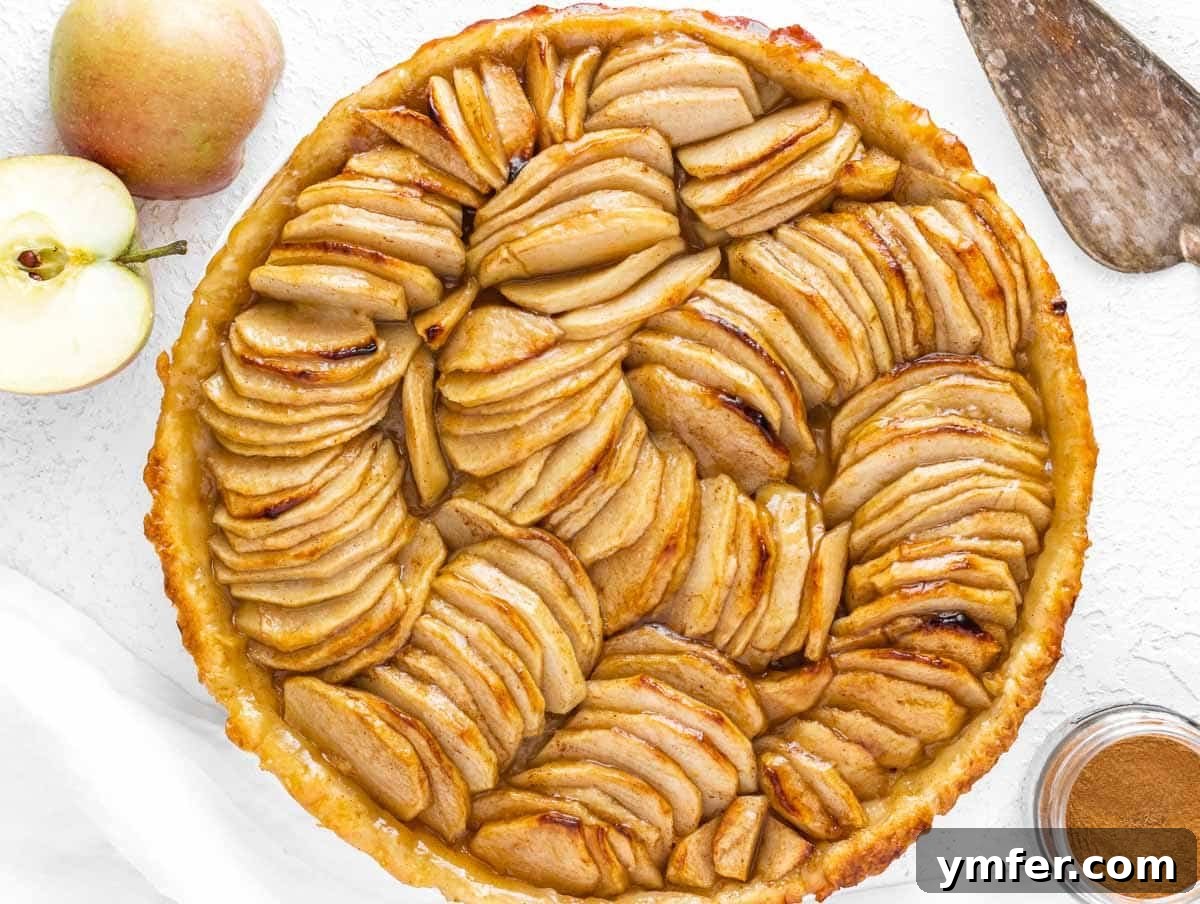 apple tart just baked, being glazed with apricot jam