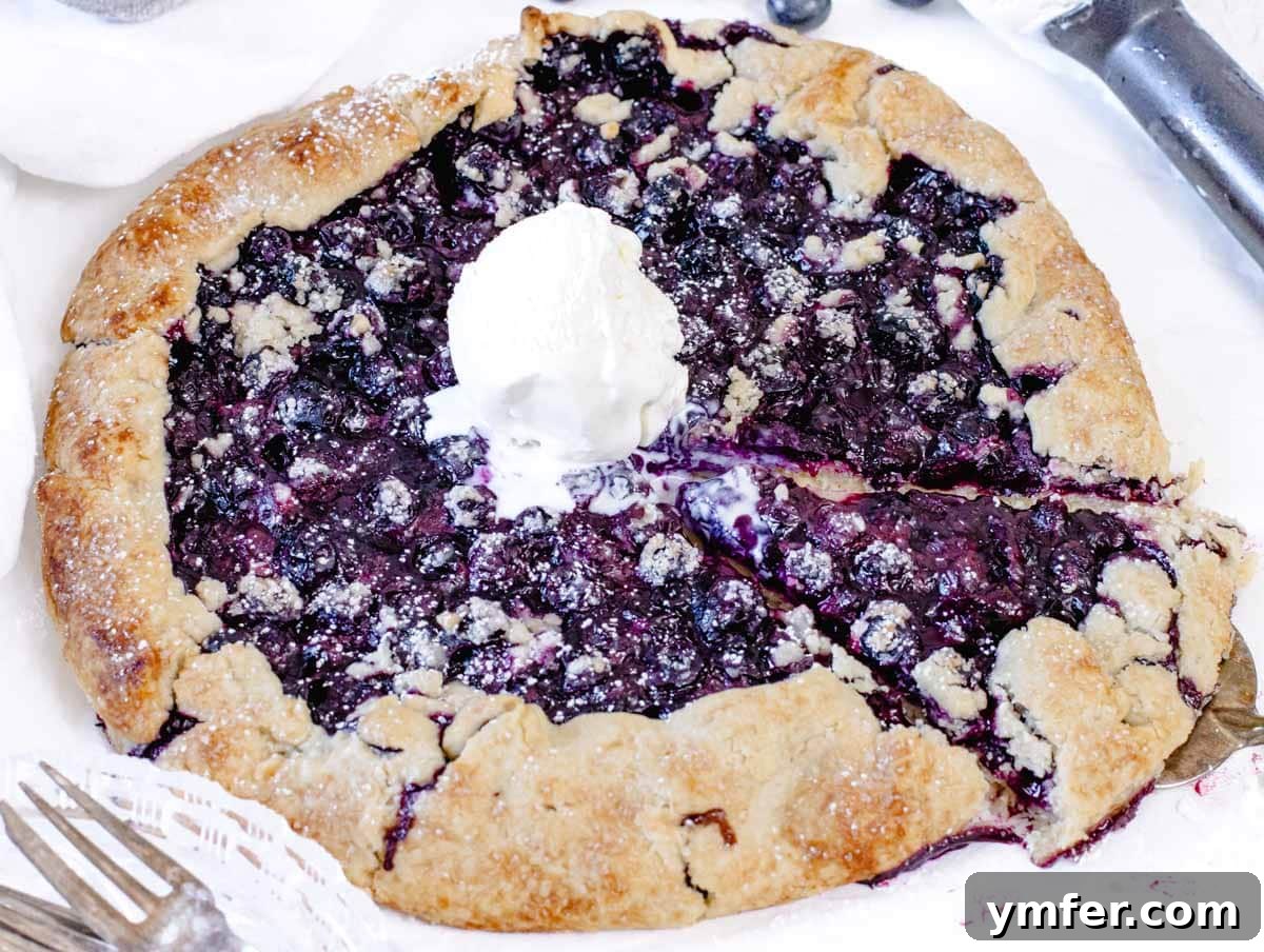 35 Effortless Dessert Delights 15 Blueberry galette with ice cream and powdered sugar, a rustic and flaky dessert