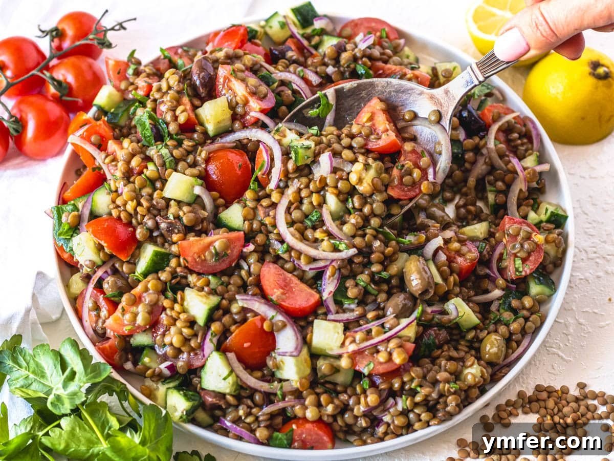 45 Effortless Vegetarian Dinner Ideas 25 Lentil salad on a white plate with a silver spoon and lemon wedges on the side