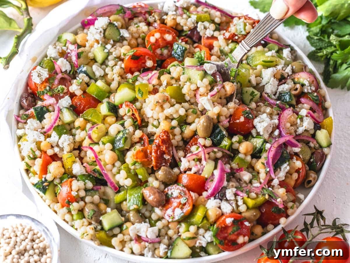 45 Effortless Vegetarian Dinner Ideas 27 Israeli couscous salad on a big white plate with a silver spoon