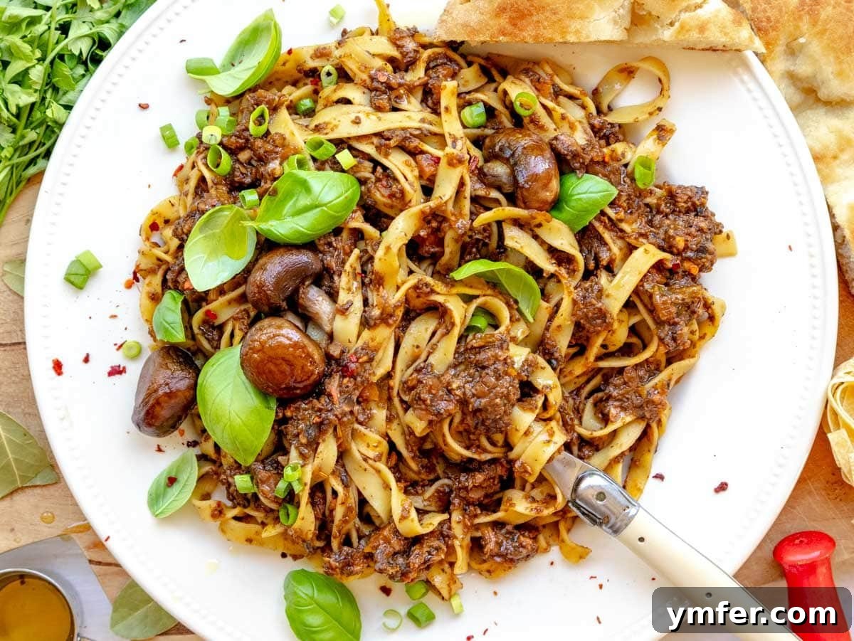 45 Effortless Vegetarian Dinner Ideas 7 mushroom bolognese on a plate with fresh basil and a fork