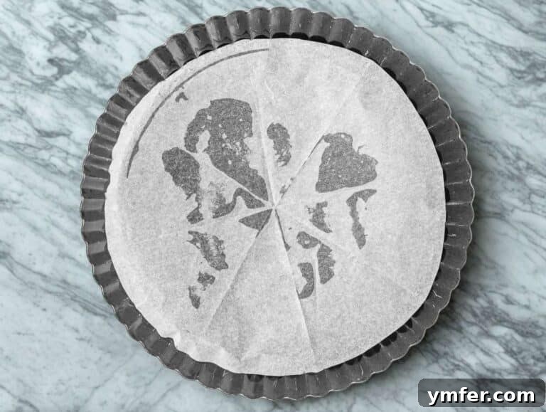 Tart pan lined with parchment paper.