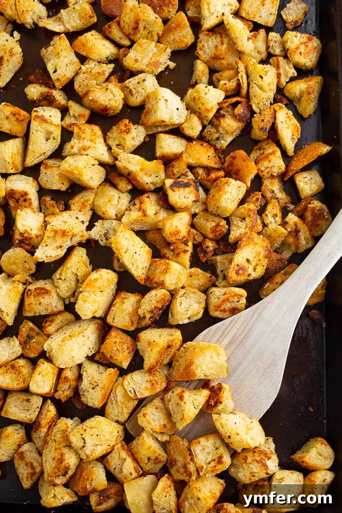 Golden homemade garlic butter croutons, ideal for enriching soups and salads. Crispy homemade garlic butter croutons, golden brown and perfectly seasoned, cooling on a baking sheet.