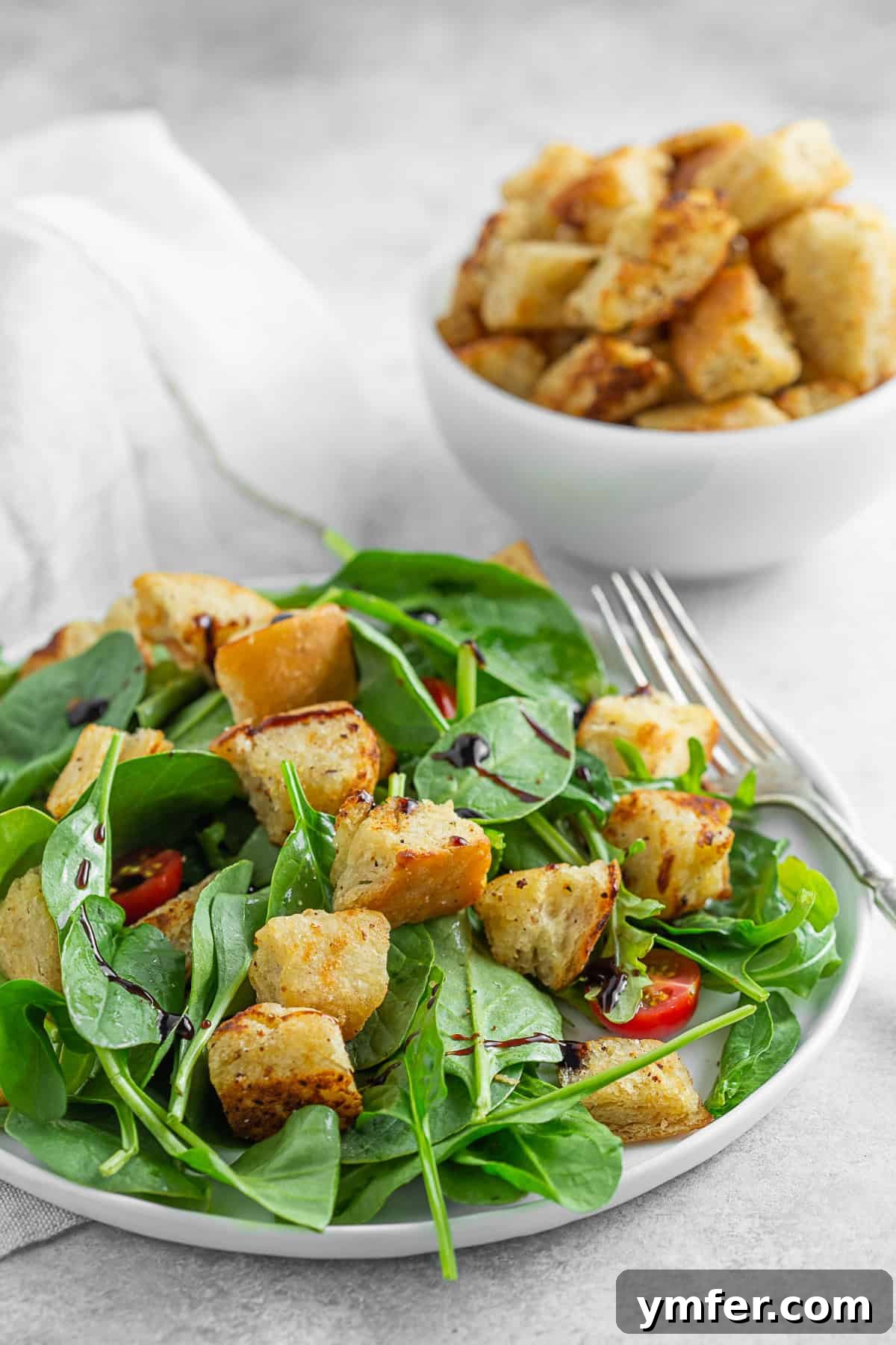 Golden Garlic Butter Croutons 2 Homemade garlic butter croutons sprinkled over a vibrant green salad with fresh ingredients.
