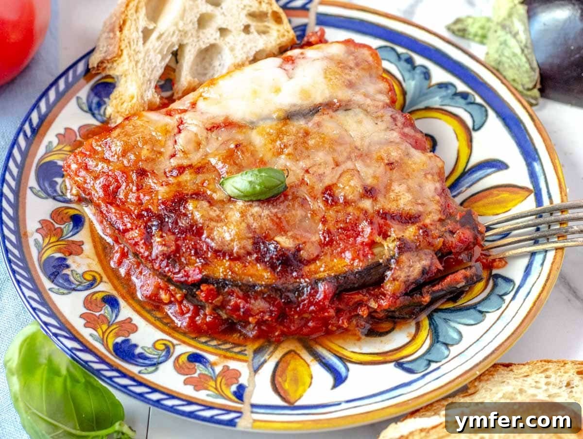 40 Flavorful Plant-Based Dinners 6 A perfectly portioned slice of golden-brown Parmigiana on a blue plate.