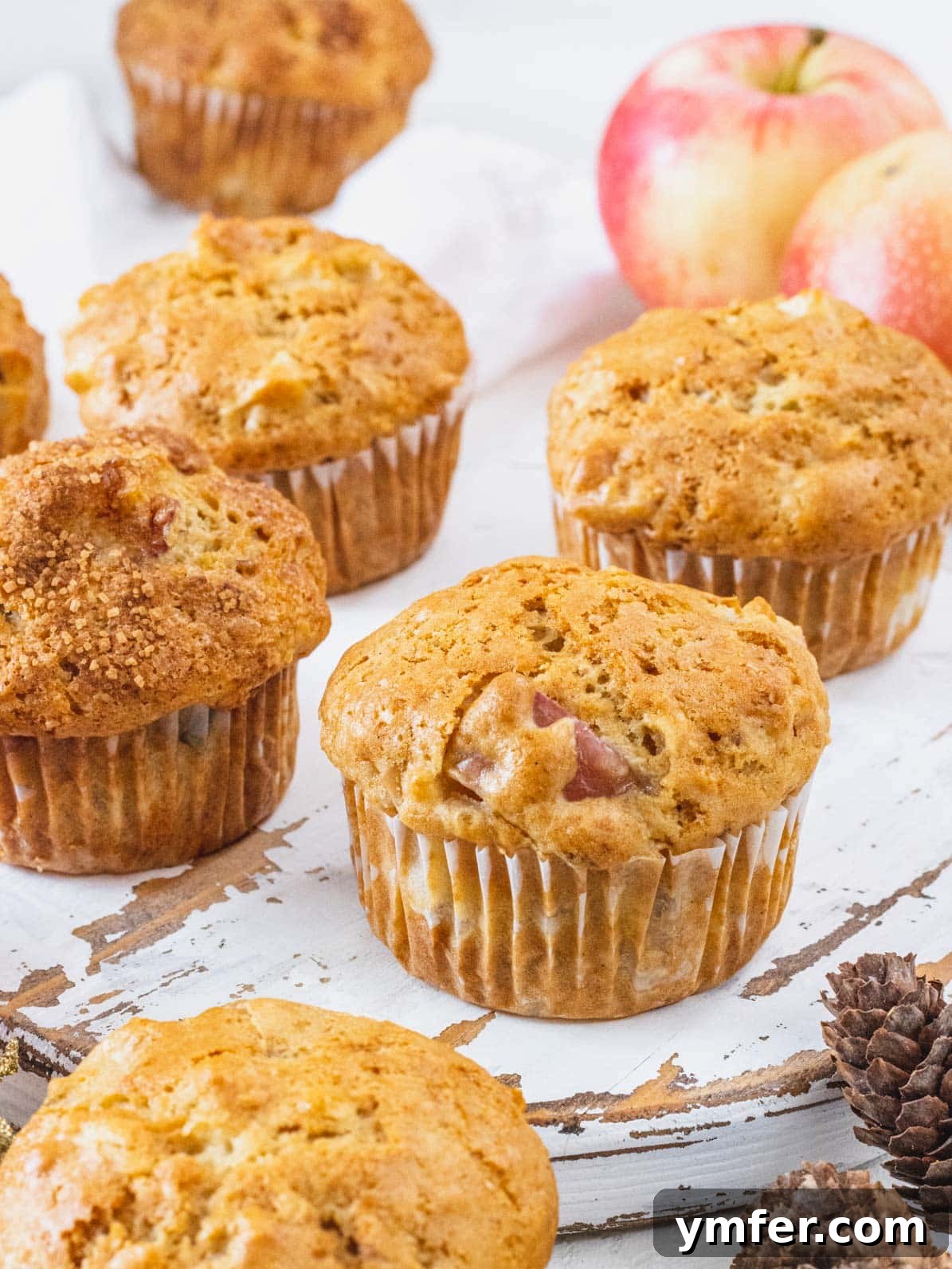 Cinnamon Apple Vegan Muffins 2 Apple muffins on a wooden tray, showcasing their golden-brown tops and inviting texture