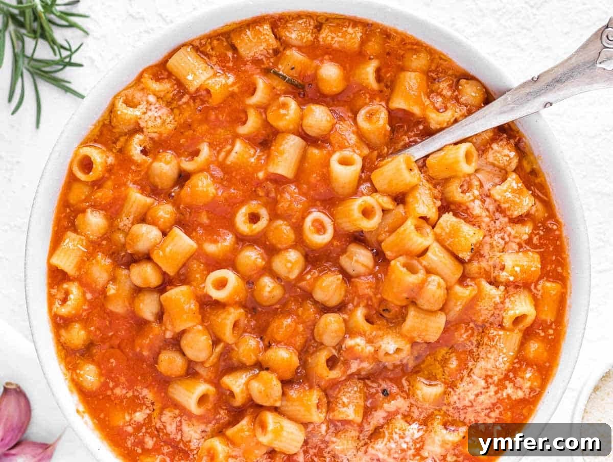 Hearty Chickpea Pasta 3 A delectable bowl of Pasta e Ceci garnished with Parmesan cheese, showcasing its rich texture.