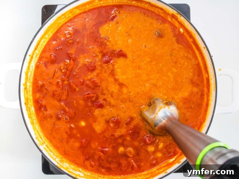 Hearty Chickpea Pasta 14 handblender in a skillet blending tomato sauce and chickpeas