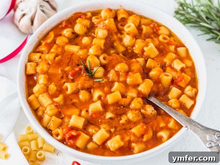 Hearty Chickpea Pasta 16 Pasta e Ceci with a silver spoon and rosemary on the side