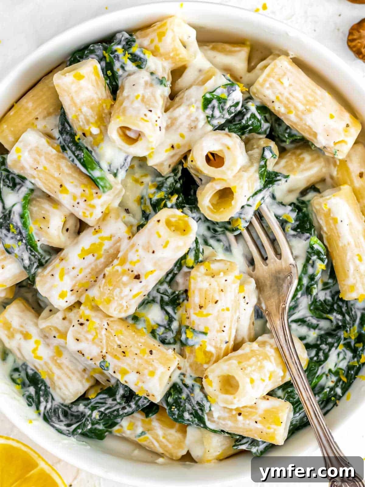 Zesty Lemon Ricotta Pasta 3 Close-up of a serving of Italian Lemon Ricotta Pasta with spinach, showing the creamy texture and fresh ingredients.