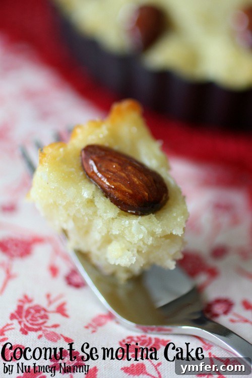 Coconut Semolina Cake by Nutmeg Nanny Close-up of the finished Coconut Semolina Cake, showing the diamond pattern and almond garnishes.
