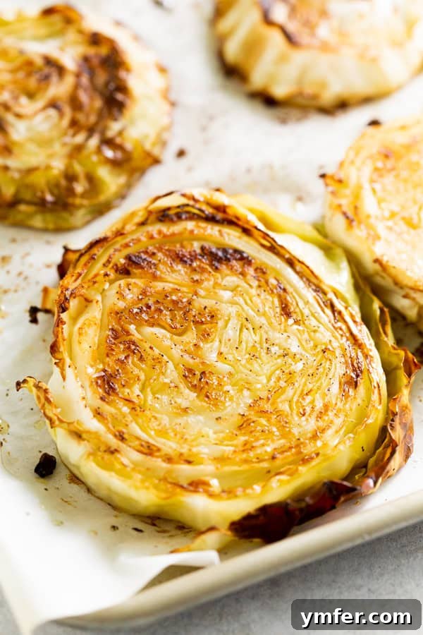 Effortless Roasted Cabbage 2 Golden brown, tender roasted cabbage slices on a baking sheet, seasoned with herbs.
