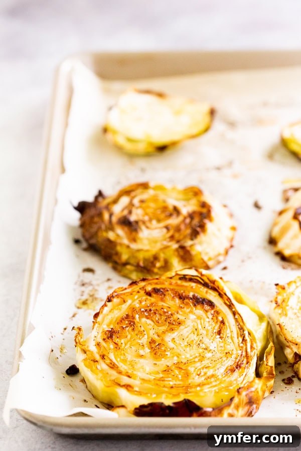 Effortless Roasted Cabbage 4 A serving of roasted cabbage with fresh lemon wedges and parsley garnish.