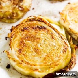 Effortless Roasted Cabbage 5 A top-down view of roasted cabbage slices on a wooden board, ready to serve.