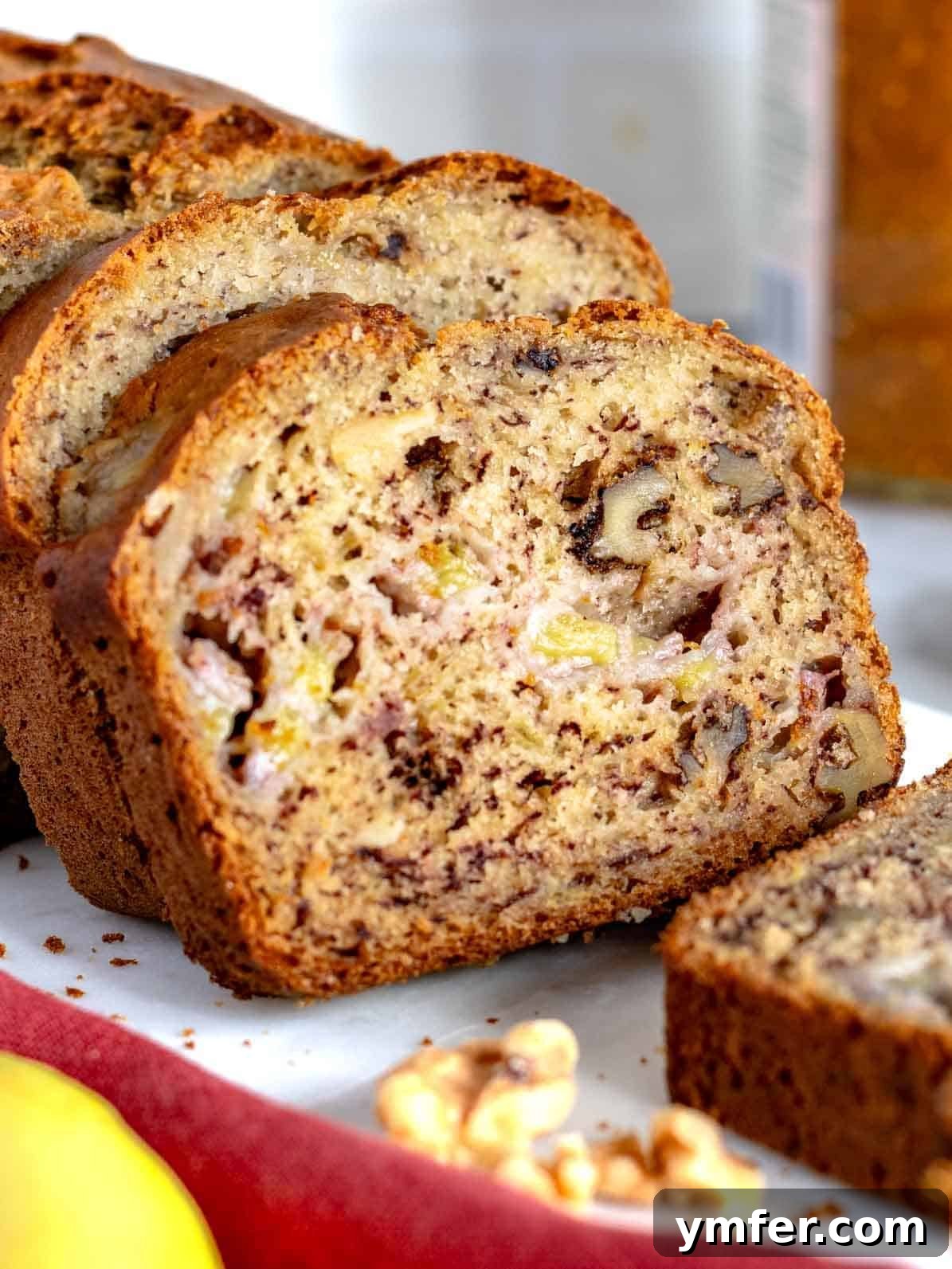 Homemade Banana Walnut Bliss 2 Perfectly sliced banana nut bread with walnuts on a rustic cutting board, ready to be enjoyed.