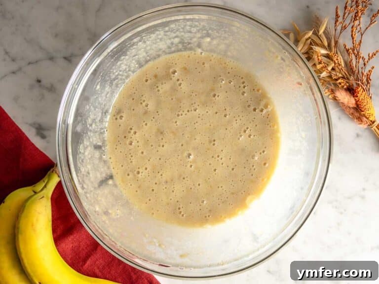 Wet ingredients for banana nut bread mixed in a bowl.