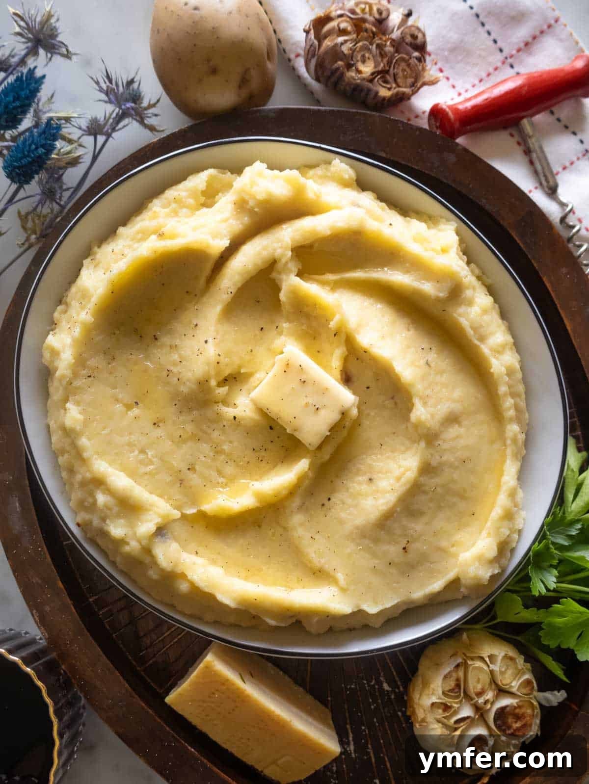 Velvety Garlic Potatoes 2 A serving of golden, roasted garlic mashed potatoes topped with fresh herbs, showcasing its rich texture and inviting warmth.
