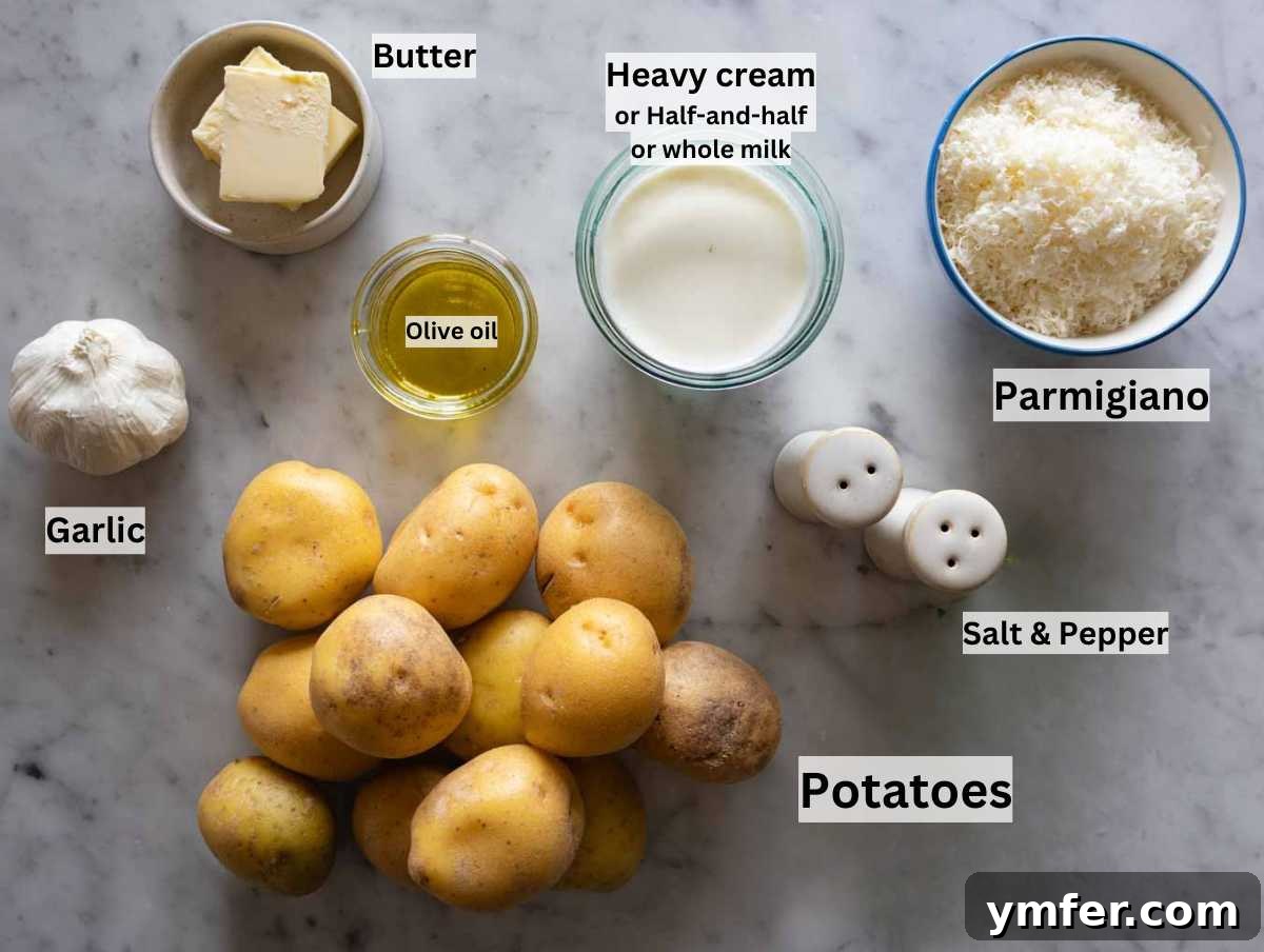 Velvety Garlic Potatoes 4 Fresh ingredients for garlic mashed potatoes laid out on a marble countertop, including whole potatoes, a head of garlic, butter, and cream.
