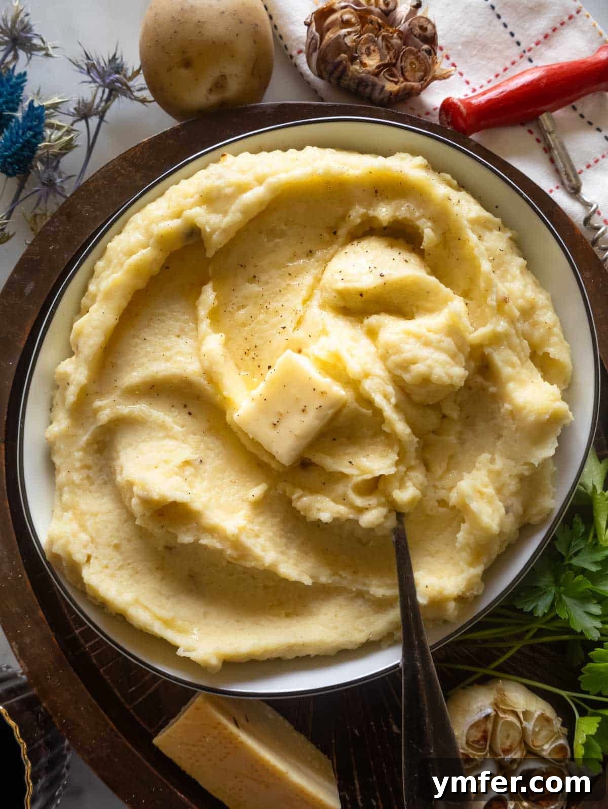 Velvety Garlic Potatoes 8 A large bowl of luscious Parmesan mashed potatoes, garnished with fresh herbs, ready to be served.