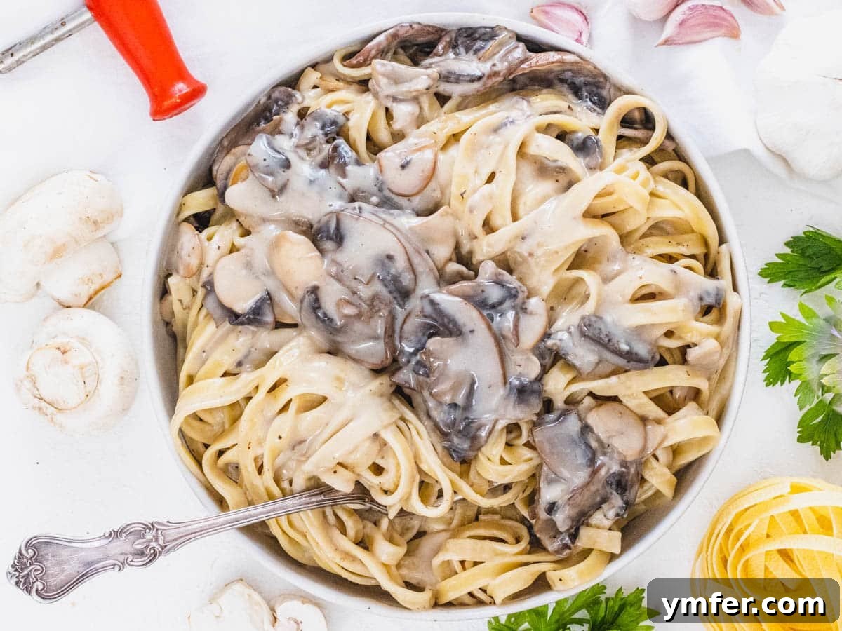Golden Garlic Mushrooms 16 Mushroom Alfredo in a bowl with a fork
